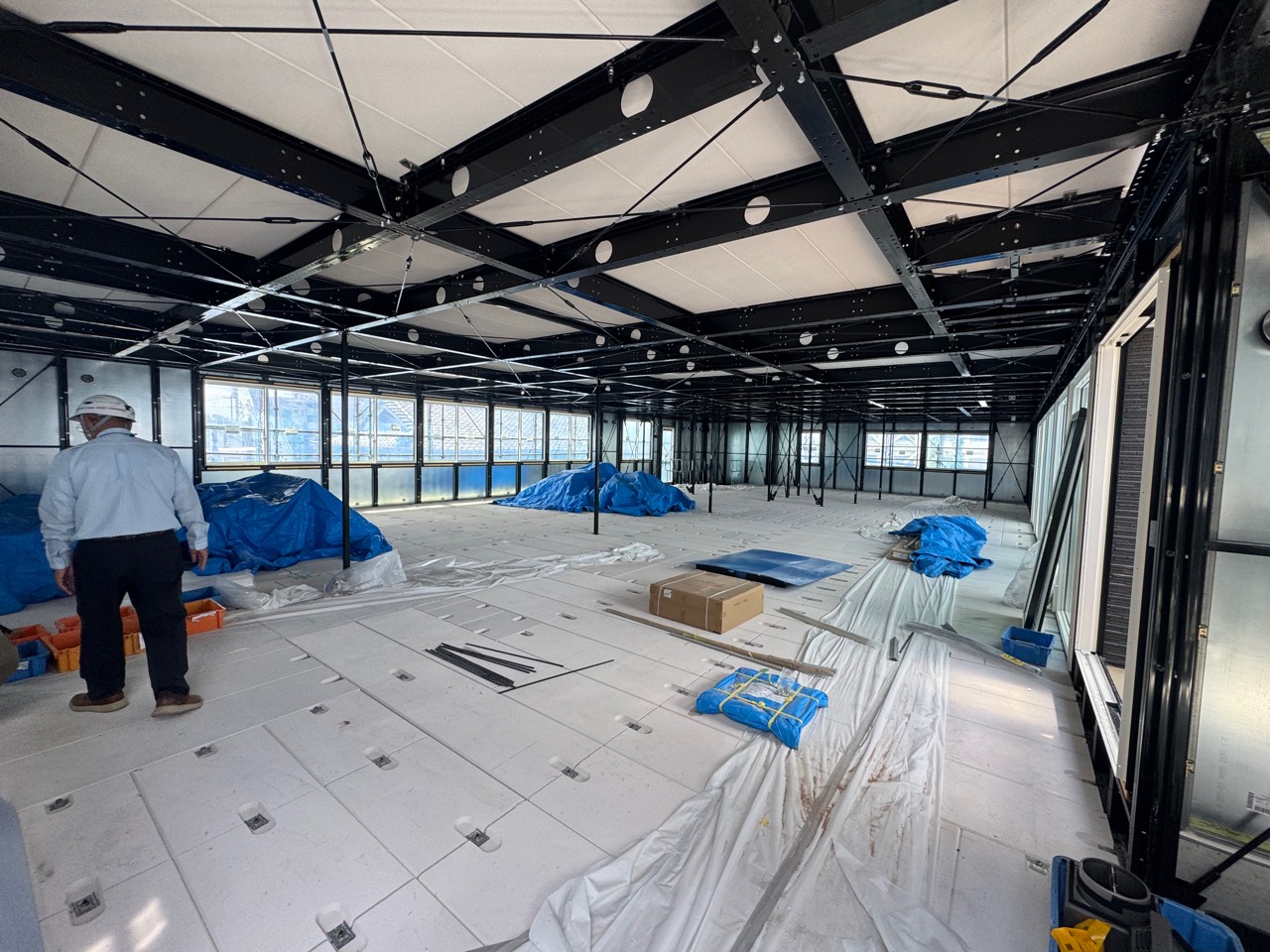 床の施工と資材の設置が進む建築工事中のクリニック内部